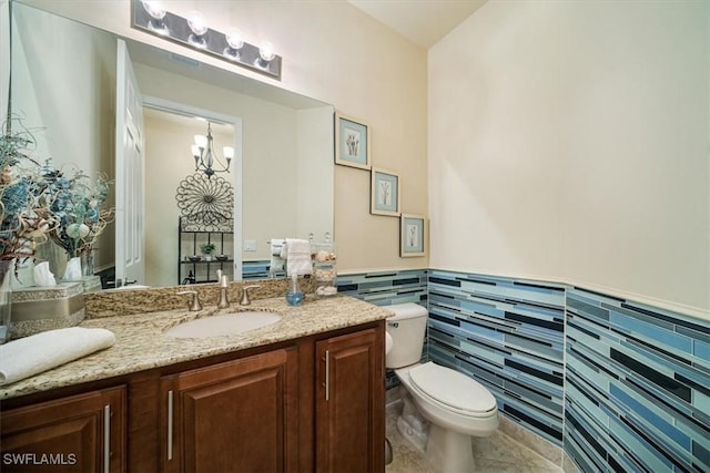 6502 Monterey Pt Unit 202, Naples, FL 34105 - half bath with a wainscoted wall, vanity, tile walls, and tile patterned floors