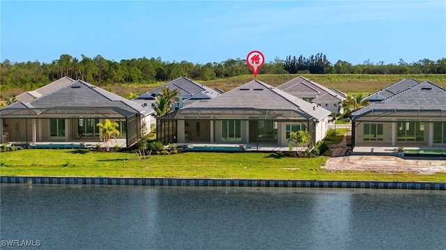 rear view of property featuring a lawn, a lanai, and a water view