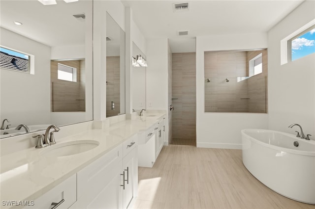 bathroom with vanity, wood-type flooring, and plus walk in shower