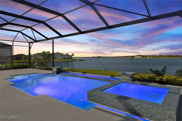 pool at dusk featuring a patio, a water view, and glass enclosure