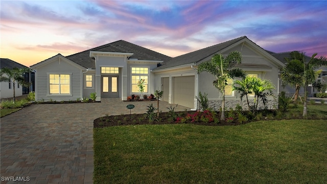 view of front of house featuring a garage and a lawn