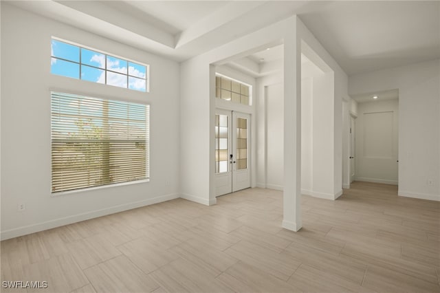 entrance foyer with a tray ceiling and a high ceiling