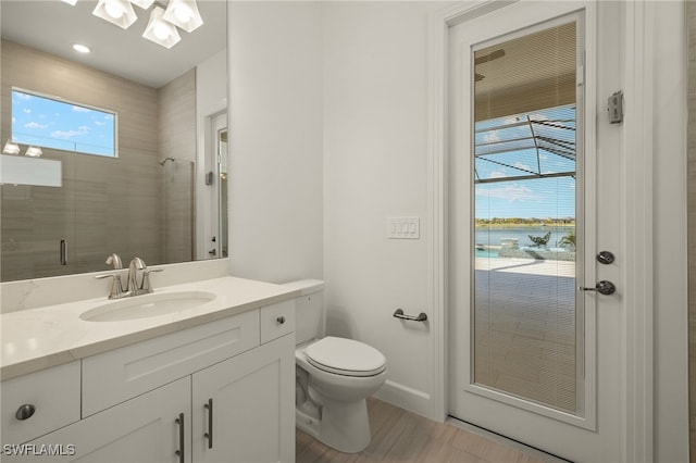 bathroom with vanity, toilet, tiled shower, a water view, and hardwood / wood-style flooring