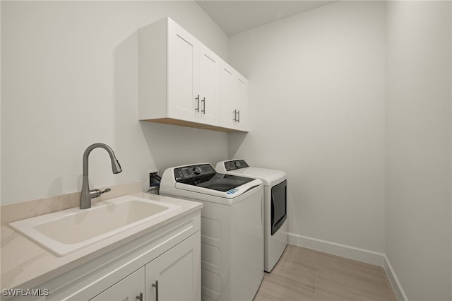 laundry area with cabinets, sink, and washing machine and clothes dryer