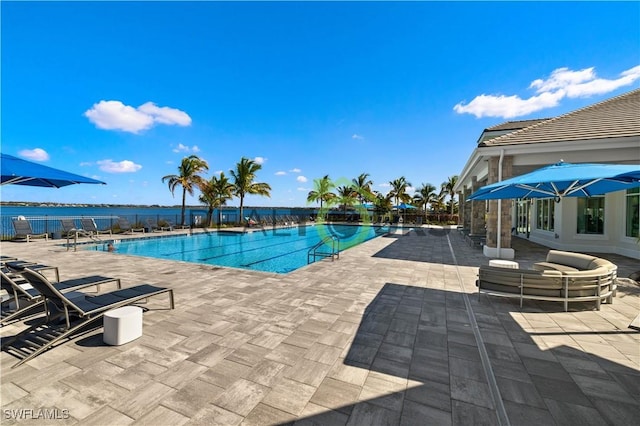 view of swimming pool with a patio area and a water view