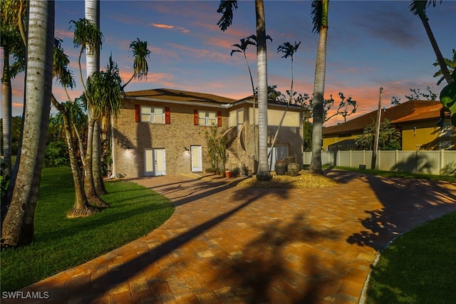 view of front of house with a patio and a lawn