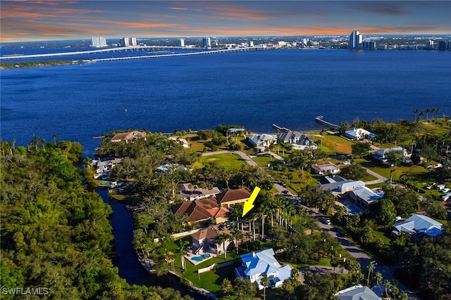 aerial view at dusk featuring a water view