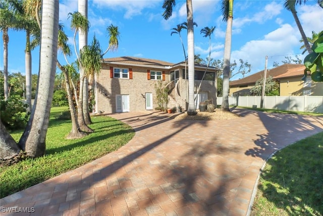 view of front of home with fence and a front lawn