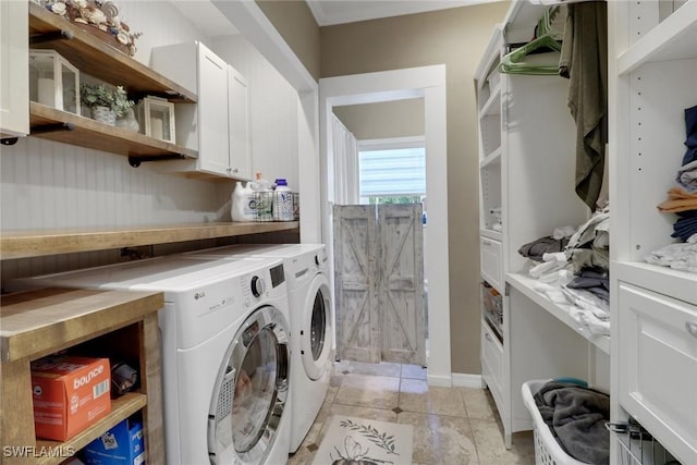 clothes washing area featuring light tile patterned floors, separate washer and dryer, and cabinet space