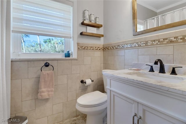 bathroom featuring ornamental molding, vanity, toilet, and tile walls