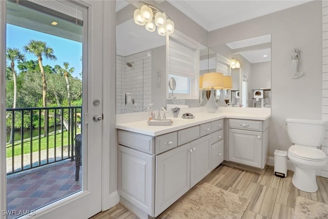 full bathroom featuring toilet, baseboards, a tile shower, and vanity