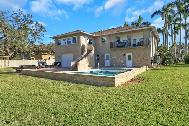 back of property featuring an attached garage, cooling unit, a balcony, fence, and a yard