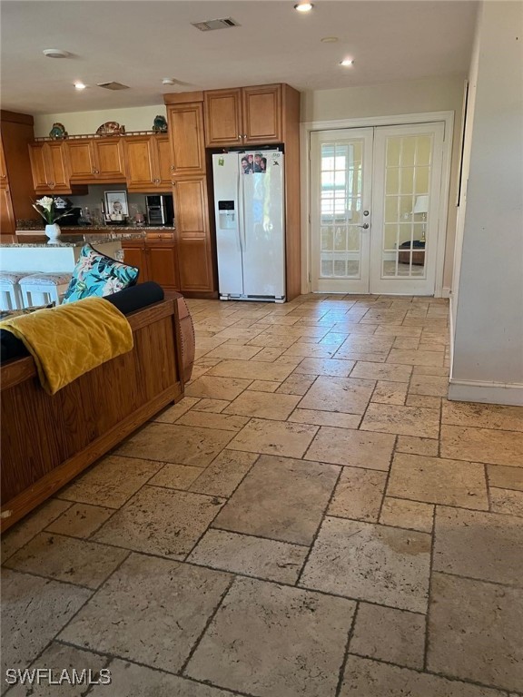 kitchen with french doors and white refrigerator with ice dispenser