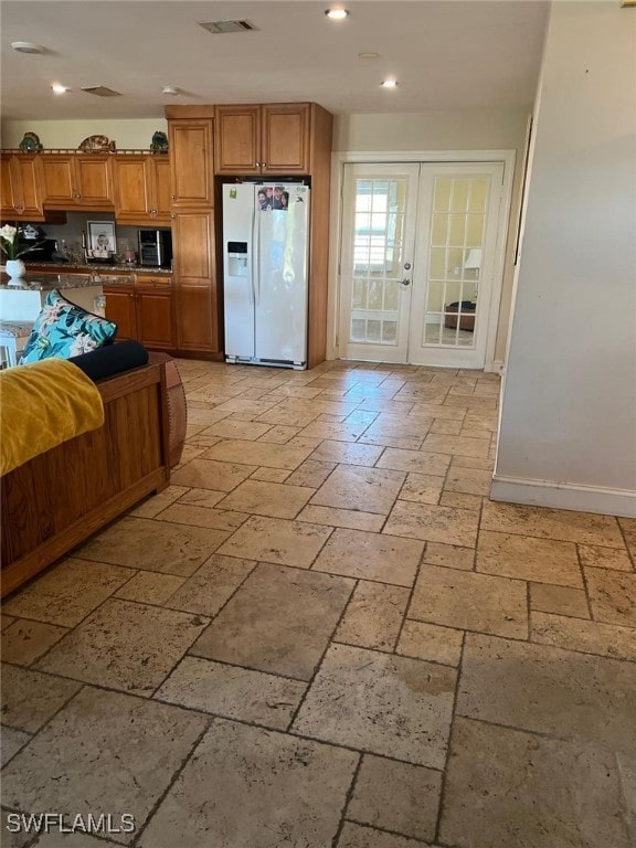 kitchen with white refrigerator with ice dispenser and french doors