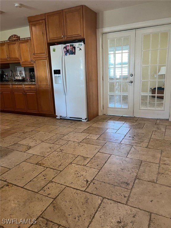 kitchen featuring white refrigerator with ice dispenser and french doors