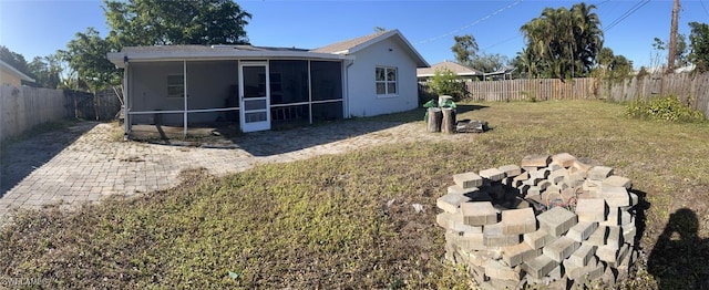 back of house with a sunroom and a yard