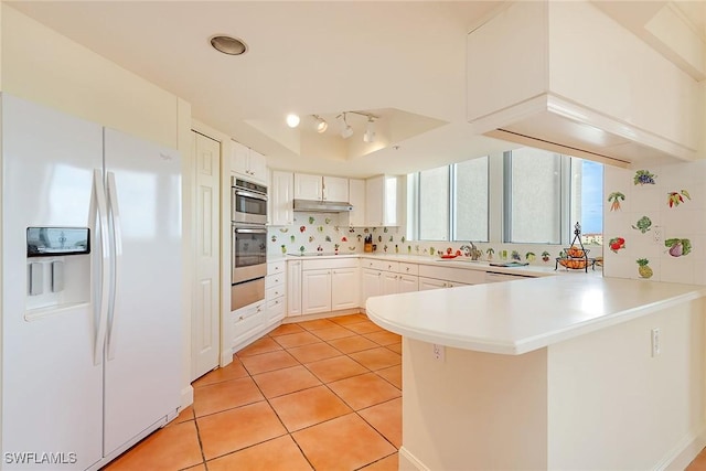 kitchen featuring white cabinets, white fridge with ice dispenser, light tile patterned floors, tasteful backsplash, and kitchen peninsula