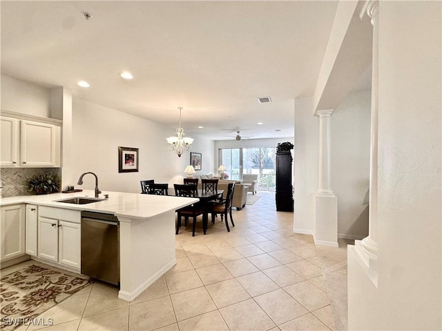 kitchen with ornate columns, dishwasher, sink, kitchen peninsula, and light tile patterned floors