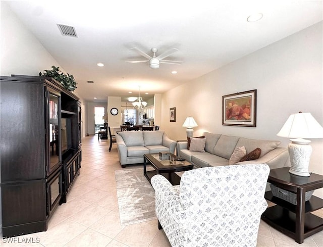 living room featuring light tile patterned floors and ceiling fan with notable chandelier