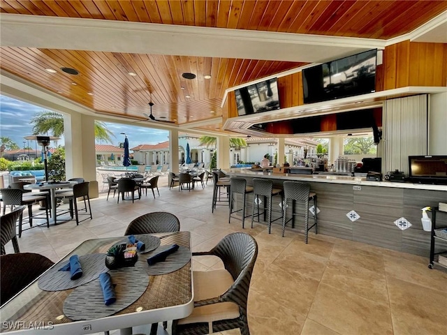 dining space with ceiling fan, light tile patterned flooring, wood ceiling, and a wealth of natural light