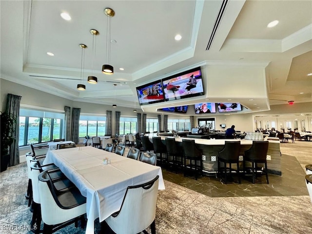 dining area with a tray ceiling and ornamental molding