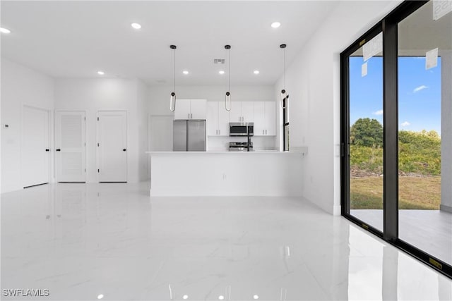 kitchen with stainless steel appliances, white cabinetry, and hanging light fixtures