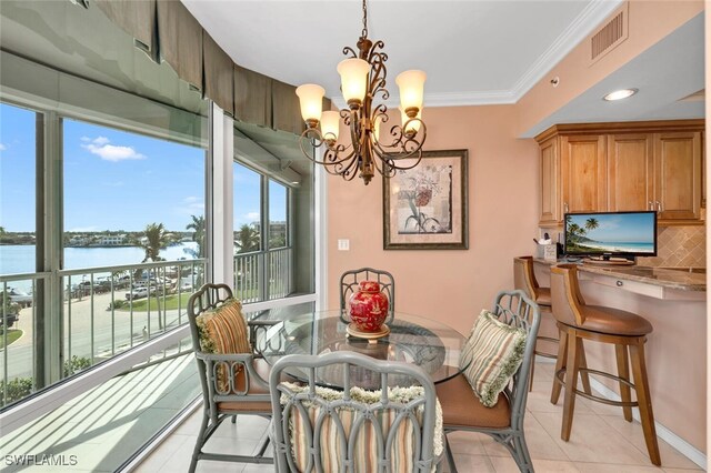 dining area featuring a water view, light tile patterned floors, crown molding, and an inviting chandelier