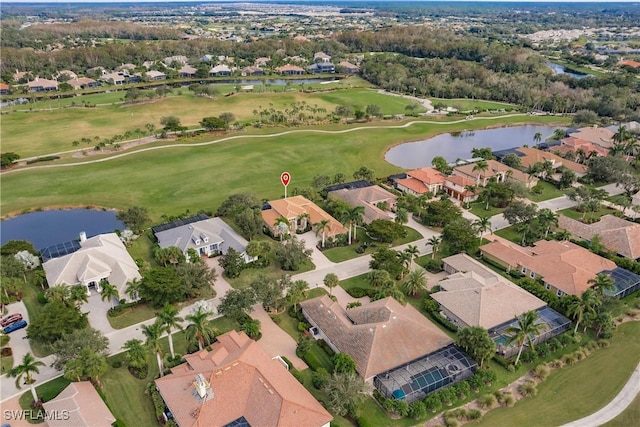 aerial view with golf course view, a water view, and a residential view