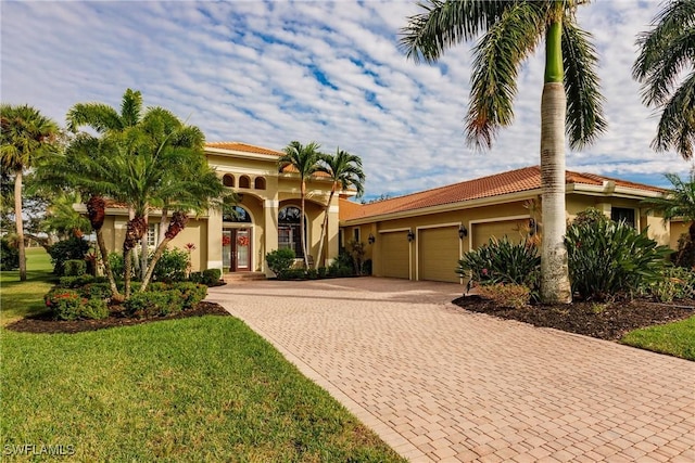 mediterranean / spanish-style house featuring a front lawn and a garage