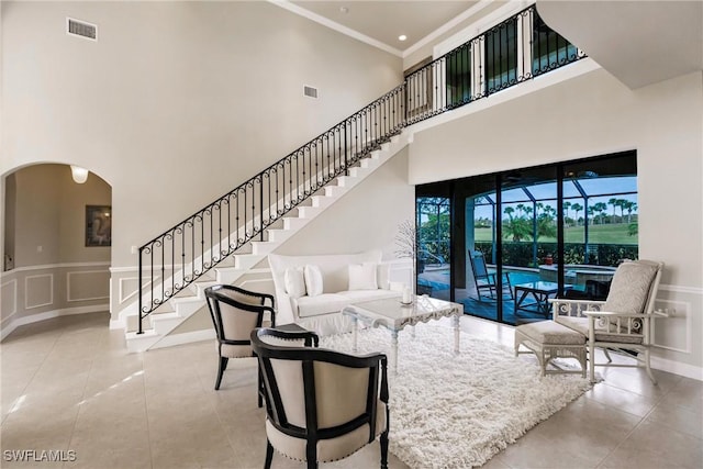 living room featuring a towering ceiling and ornamental molding