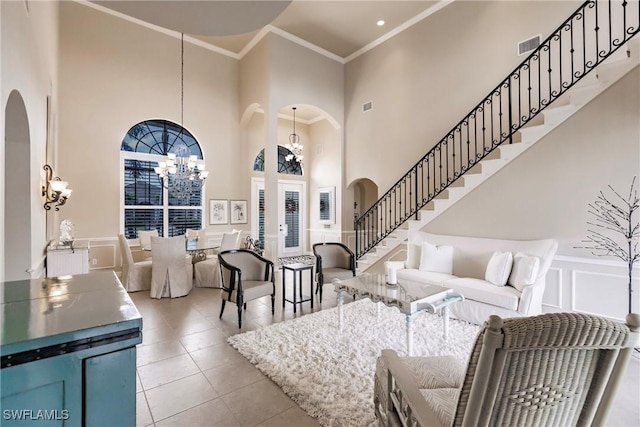 tiled living room featuring crown molding, a towering ceiling, and an inviting chandelier