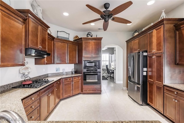 kitchen with ceiling fan, light stone counters, and appliances with stainless steel finishes