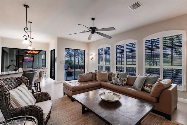 living room with ceiling fan with notable chandelier and light tile patterned flooring