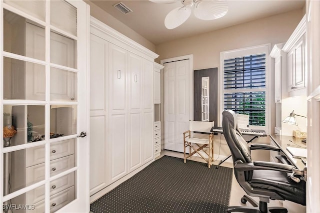 office with dark carpet and ceiling fan