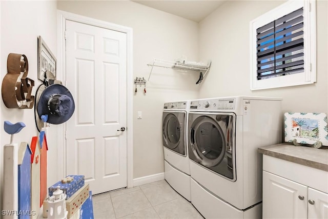 laundry area featuring washing machine and dryer and light tile patterned flooring