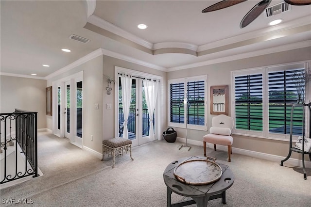 sitting room featuring french doors, a tray ceiling, crown molding, and light colored carpet