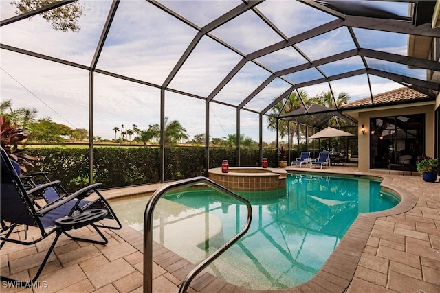 view of pool featuring an in ground hot tub, glass enclosure, and a patio area