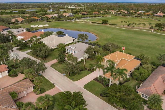 drone / aerial view featuring golf course view, a water view, and a residential view