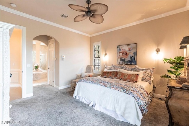 carpeted bedroom featuring arched walkways, visible vents, baseboards, ensuite bath, and crown molding