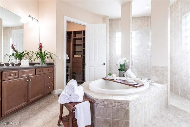 bathroom featuring tile patterned flooring, vanity, and a bath