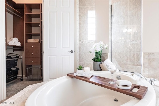 full bathroom with a garden tub and tile walls