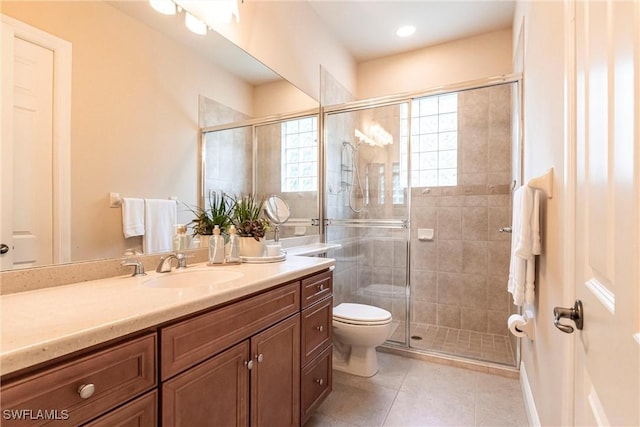 bathroom featuring toilet, a stall shower, vanity, and tile patterned floors