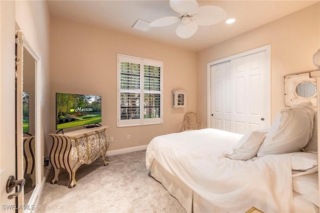 bedroom featuring light carpet, ceiling fan, baseboards, and a closet