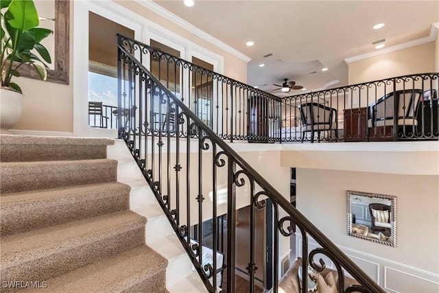 stairs featuring visible vents, a ceiling fan, ornamental molding, a decorative wall, and recessed lighting