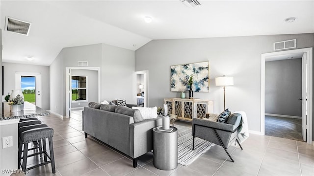 living room featuring tile patterned floors and vaulted ceiling