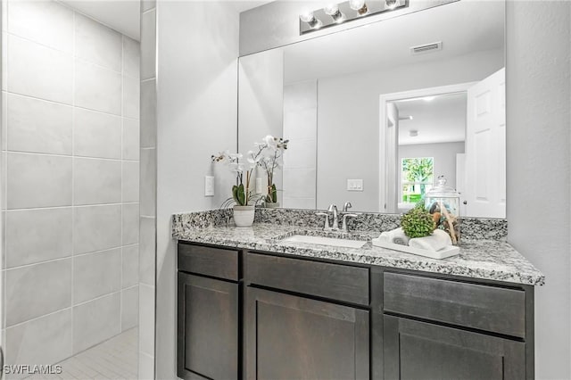 bathroom with vanity and tiled shower