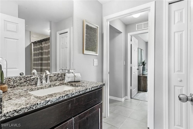 bathroom with a shower with curtain, vanity, and tile patterned floors