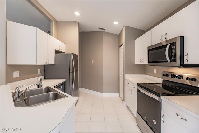 kitchen with sink, white cabinets, light tile patterned flooring, and appliances with stainless steel finishes