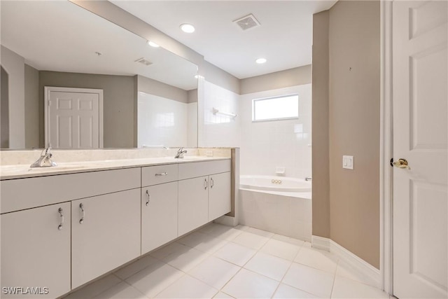 bathroom with vanity, tile patterned floors, and tiled tub