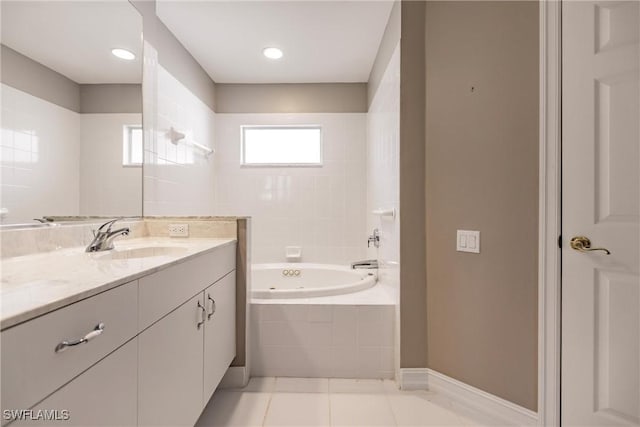 bathroom featuring tiled tub, tile patterned flooring, and vanity